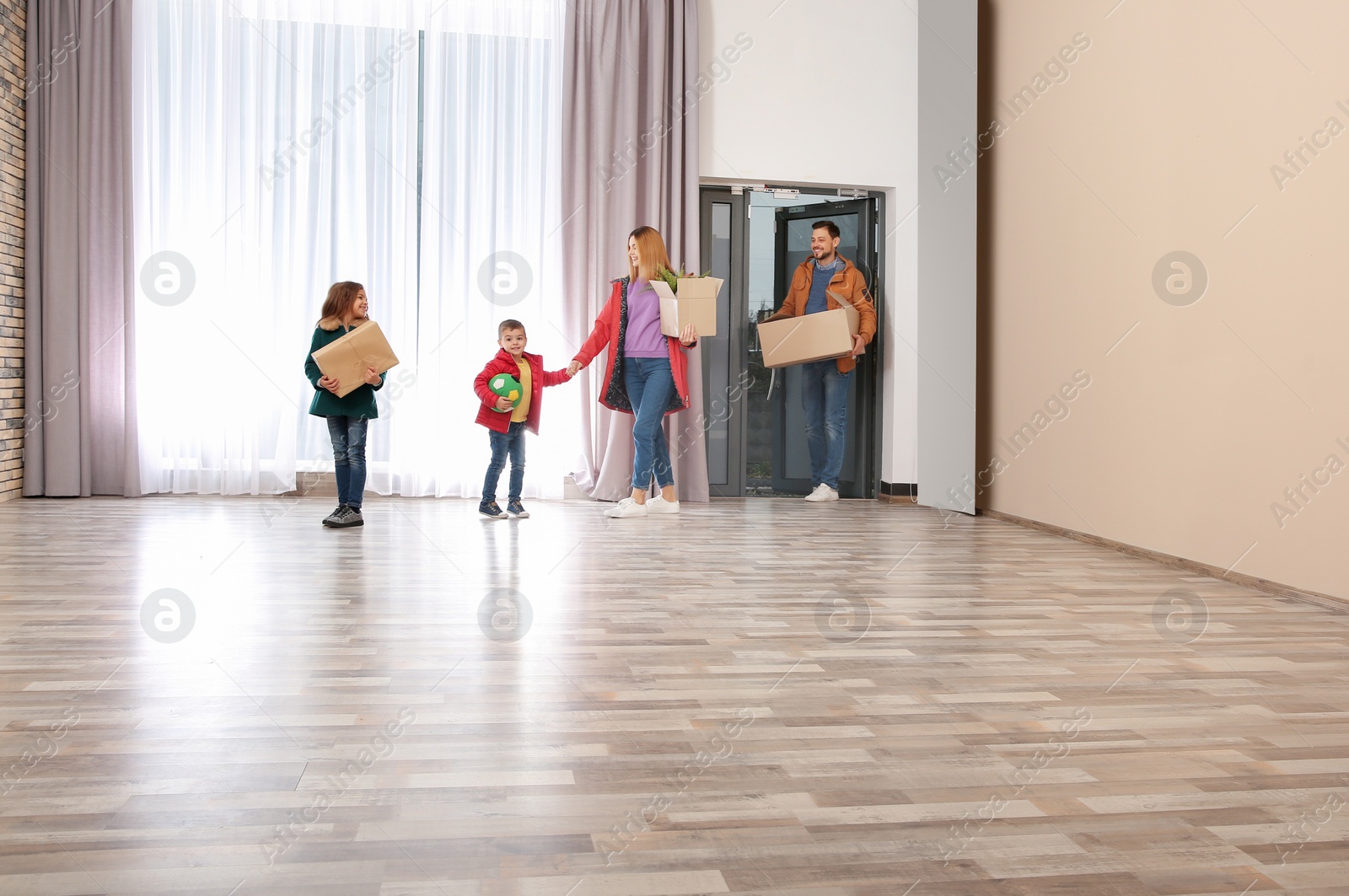 Photo of Happy family with moving boxes in their new house