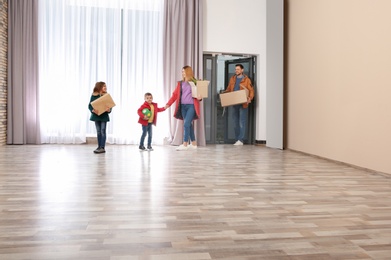 Happy family with moving boxes in their new house