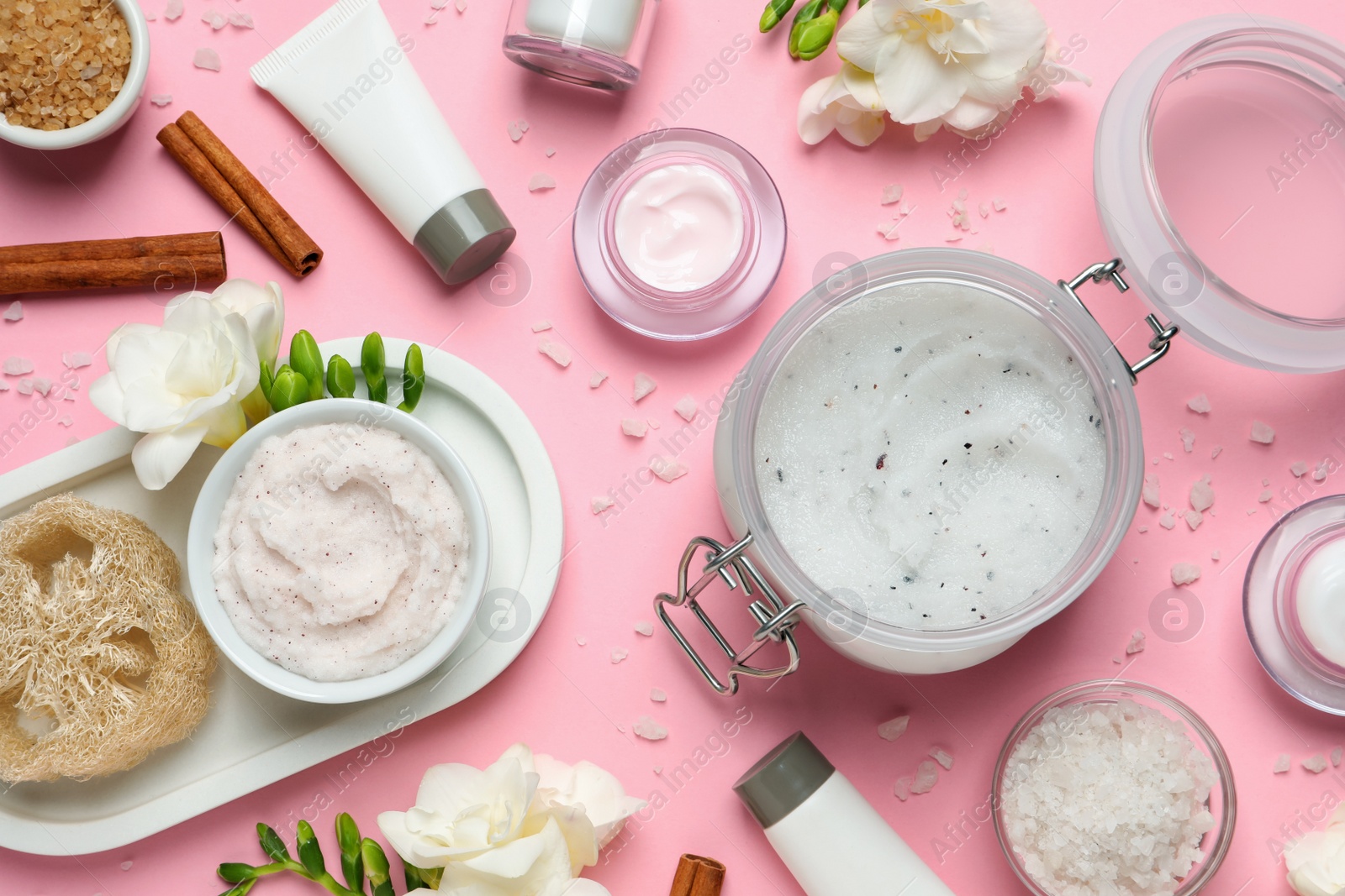 Photo of Flat lay composition with body scrubs on pink background