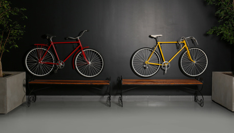 Photo of Color bicycles hanging on black wall indoors