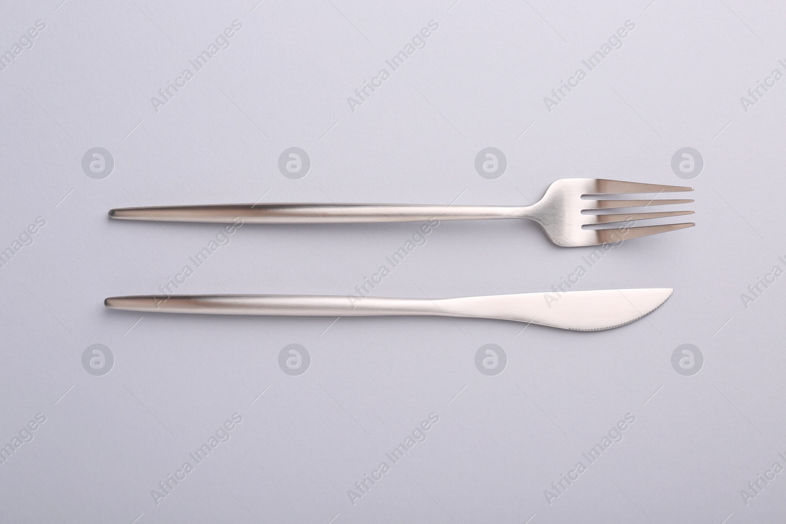 Photo of Stylish cutlery on grey table, top view