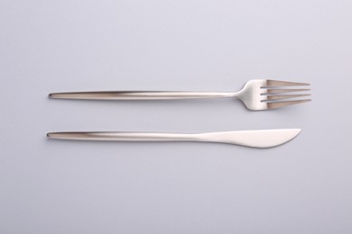 Stylish cutlery on grey table, top view