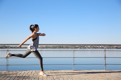 Sporty woman running outdoors on sunny morning