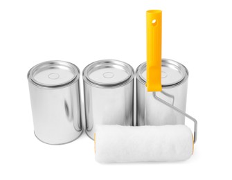 Photo of Cans of paints and roller on white background