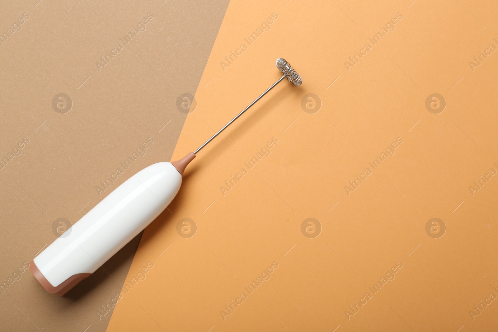 Photo of White milk frother wand on color background, top view. Space for text