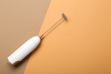 White milk frother wand on color background, top view. Space for text