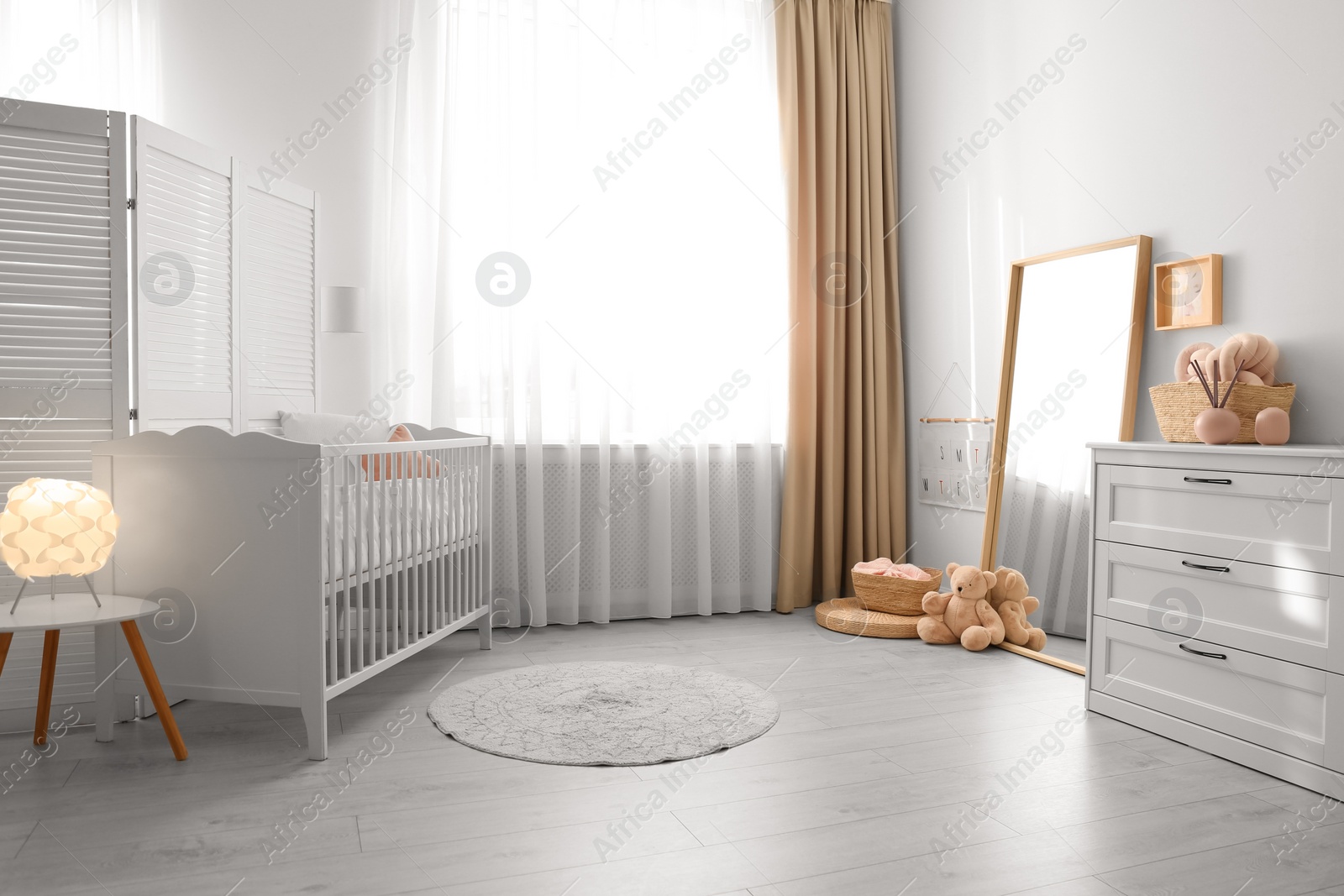 Photo of Beautiful nursery interior with white chest of drawers