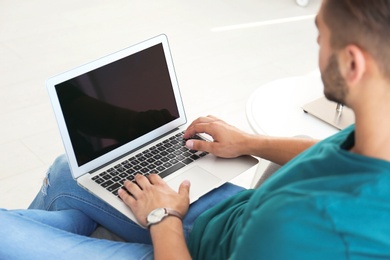 Photo of Man in casual clothes using laptop at home