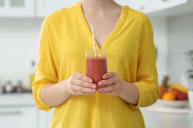 Woman with delicious smoothie in kitchen, closeup