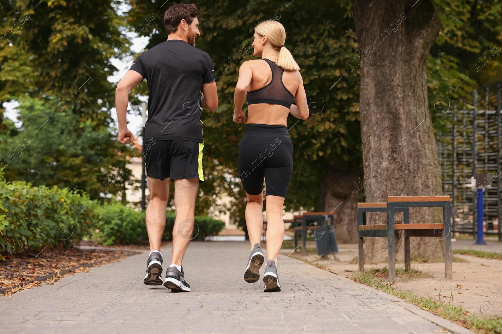 Photo of Healthy lifestyle. Happy couple running in park, back view