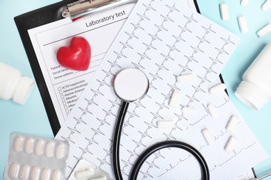 Flat lay composition with stethoscope and pills on color background. Cardiology service