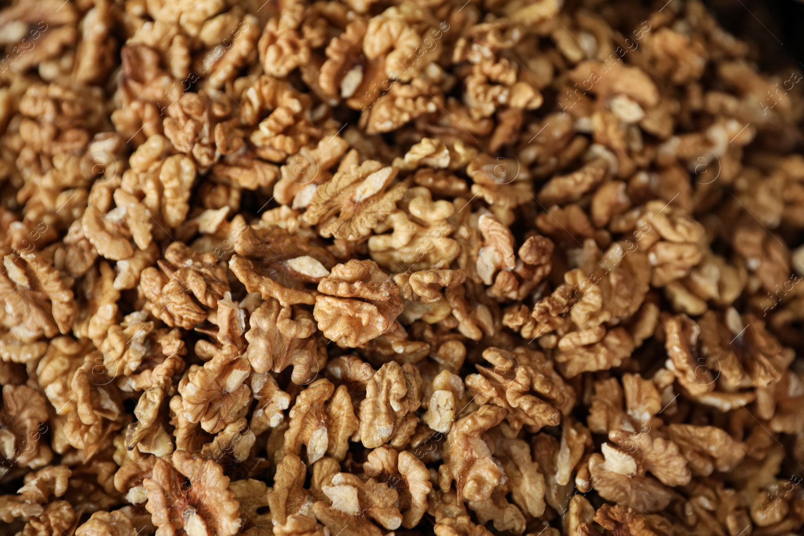 Photo of Heap of delicious walnuts as background, top view