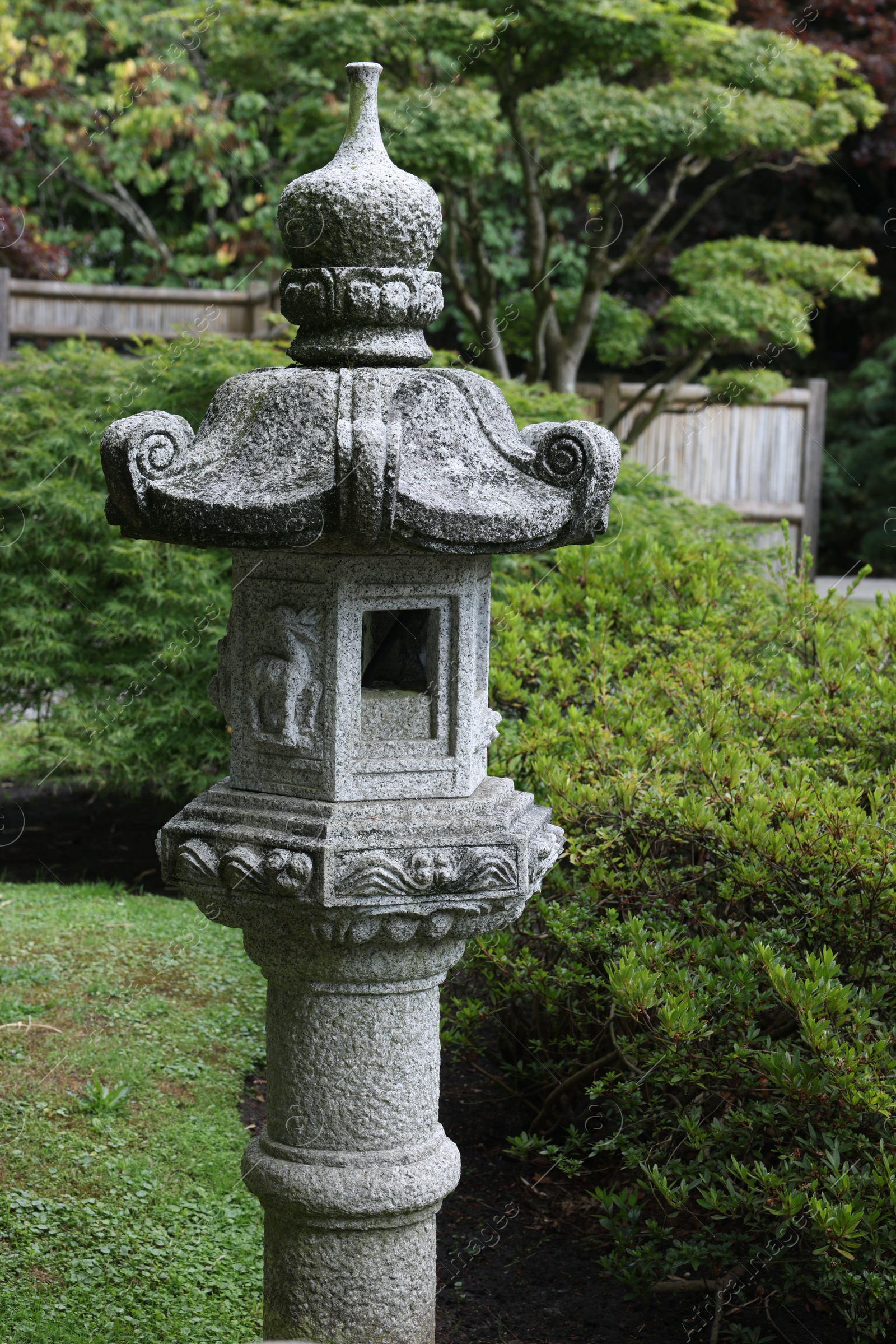 Photo of Beautiful stone streetlight and green plants in park