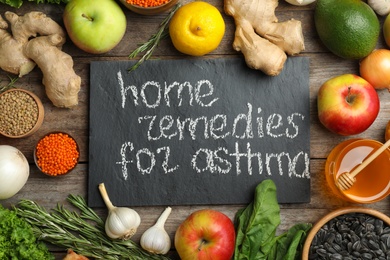 Natural products and slate board with text HOME REMEDIES FOR ASTHMA on wooden background, flat lay