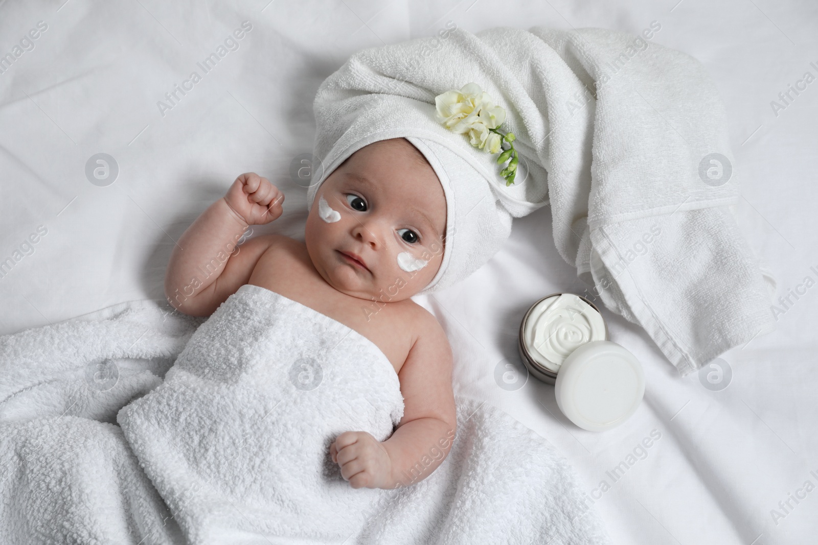 Photo of Cute little baby with cream on face, top view