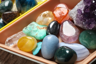 Photo of Plastic tray with different beautiful gemstones on table