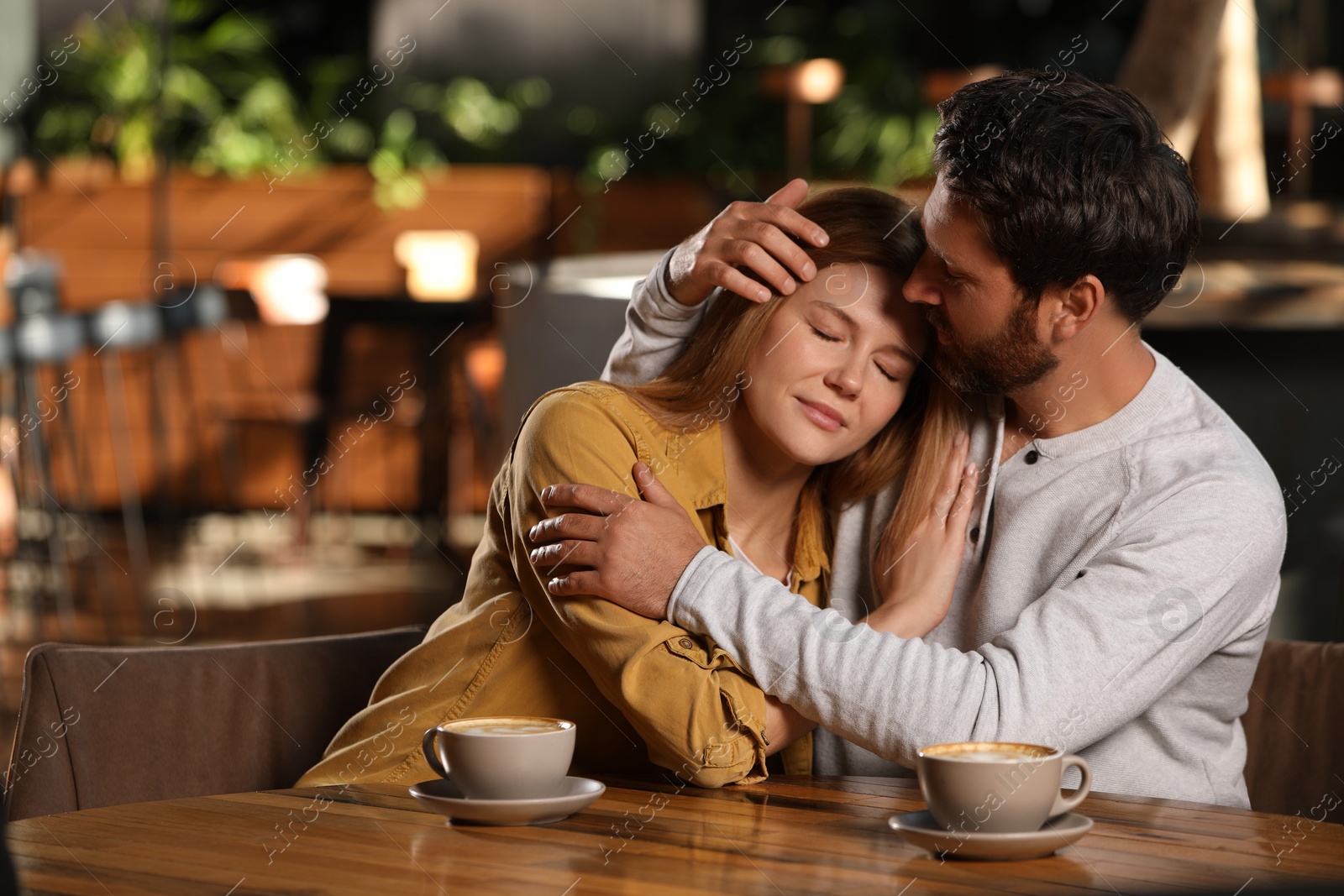 Photo of Romantic date. Lovely couple spending time together in cafe