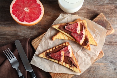 Photo of Tasty toasts with grapefruit, chocolate paste and chia seeds served on table