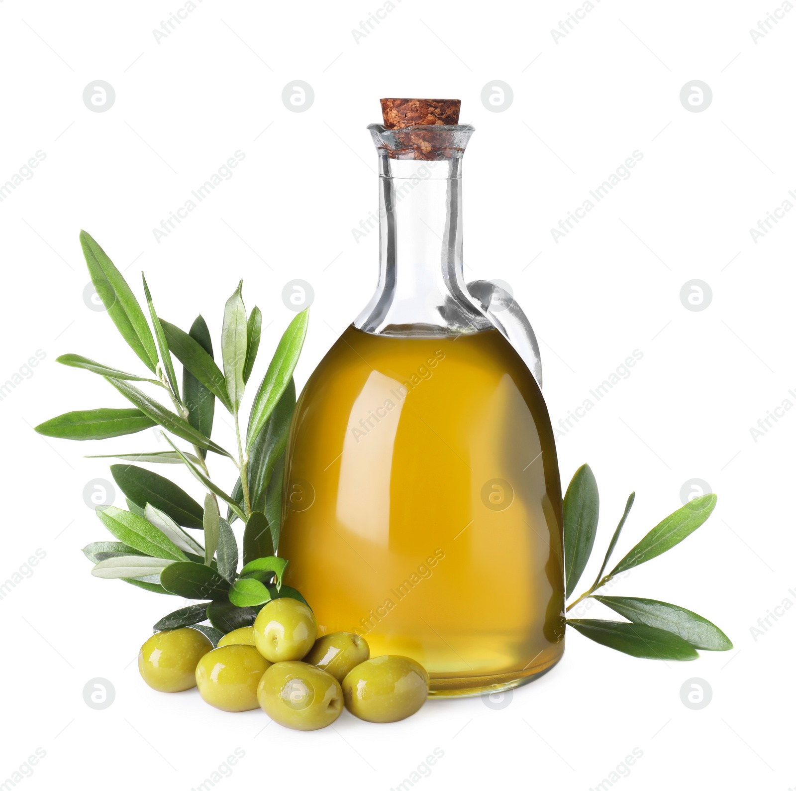 Photo of Glass jug of cooking oil, ripe olives and green leaves isolated on white