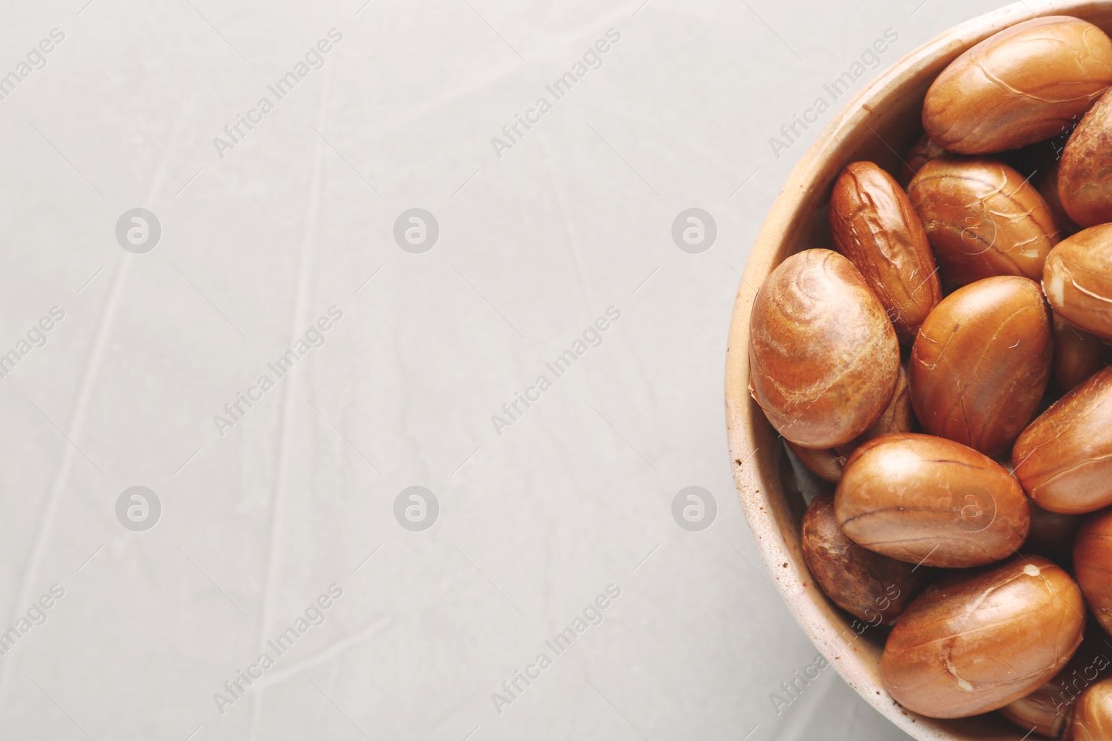 Photo of Bowl of jackfruit seeds on light table, top view. Space for text