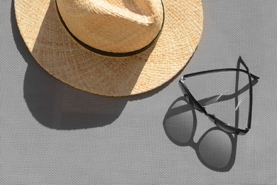 Photo of Stylish sunglasses and straw hat on grey surface, flat lay