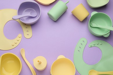 Photo of Flat lay composition with baby feeding accessories and bib on violet background, space for text