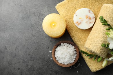 Flat lay composition with different spa products and candle on grey table. Space for text