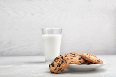 Plate with tasty chocolate cookies on gray table