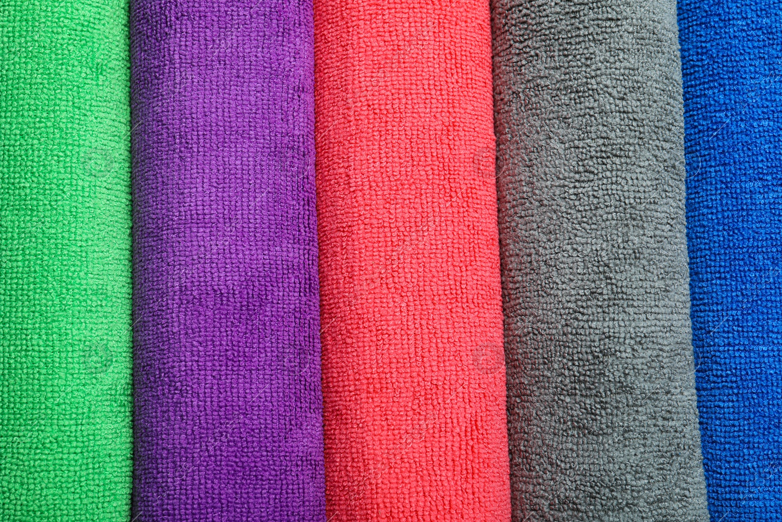 Photo of Many colorful microfiber cloths as background, top view