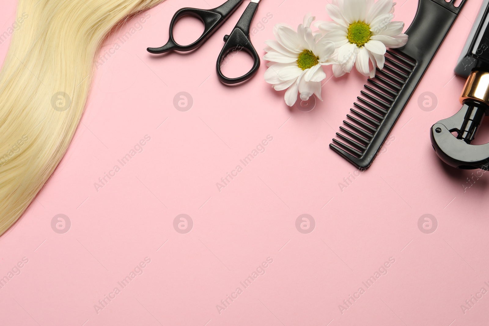 Photo of Flat lay composition with different hairdresser tools and flowers on pink background, space for text