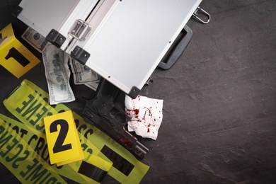 Photo of Flat lay composition with evidences and crime scene markers on black background