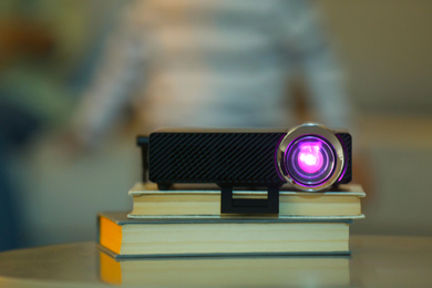 Photo of Modern video projector on wooden table at home