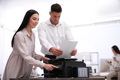 Employees using new modern printer in office
