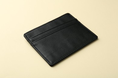 Photo of Empty leather card holder on beige background