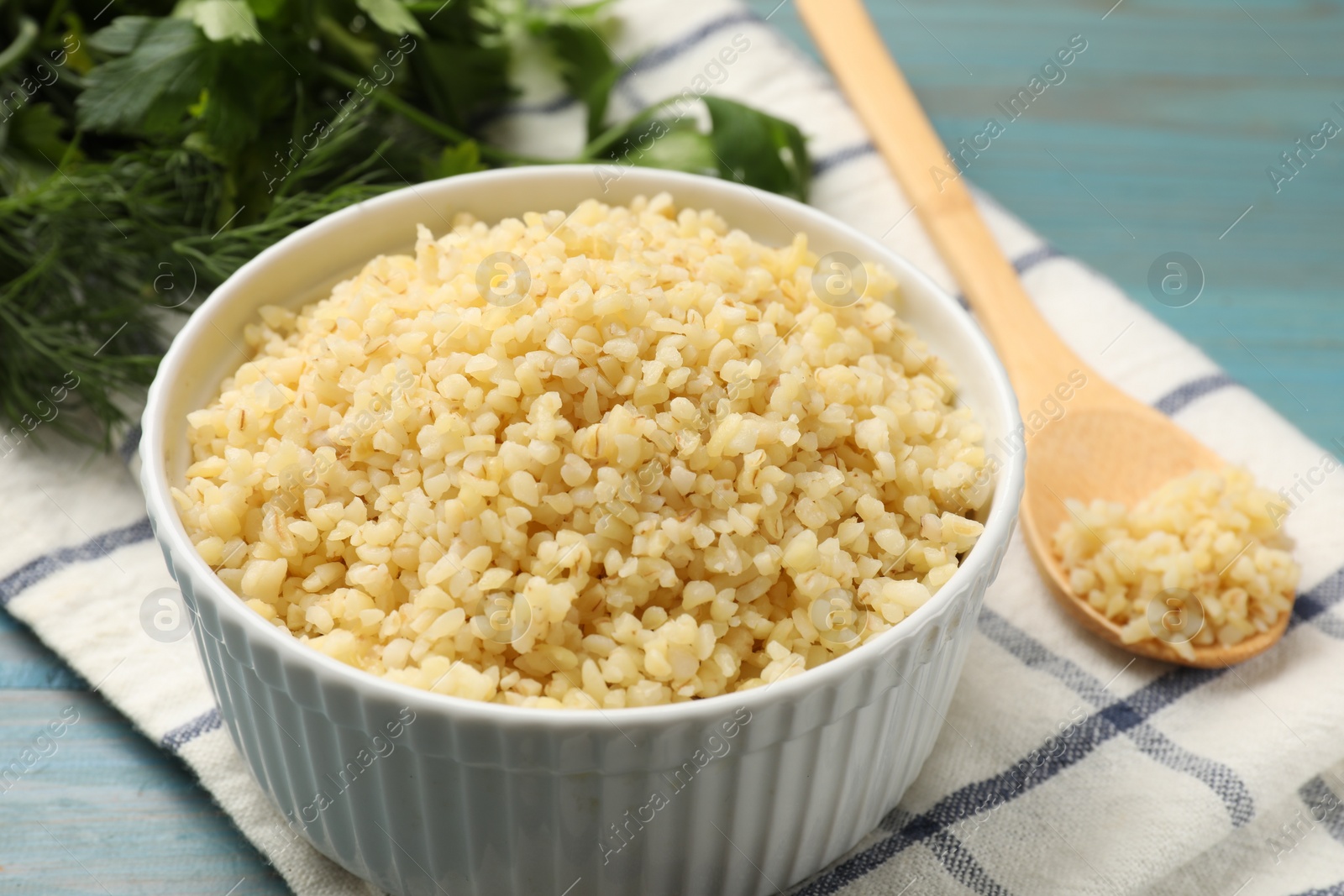 Photo of Delicious bulgur in bowl on table, closeup