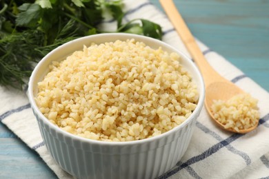 Photo of Delicious bulgur in bowl on table, closeup