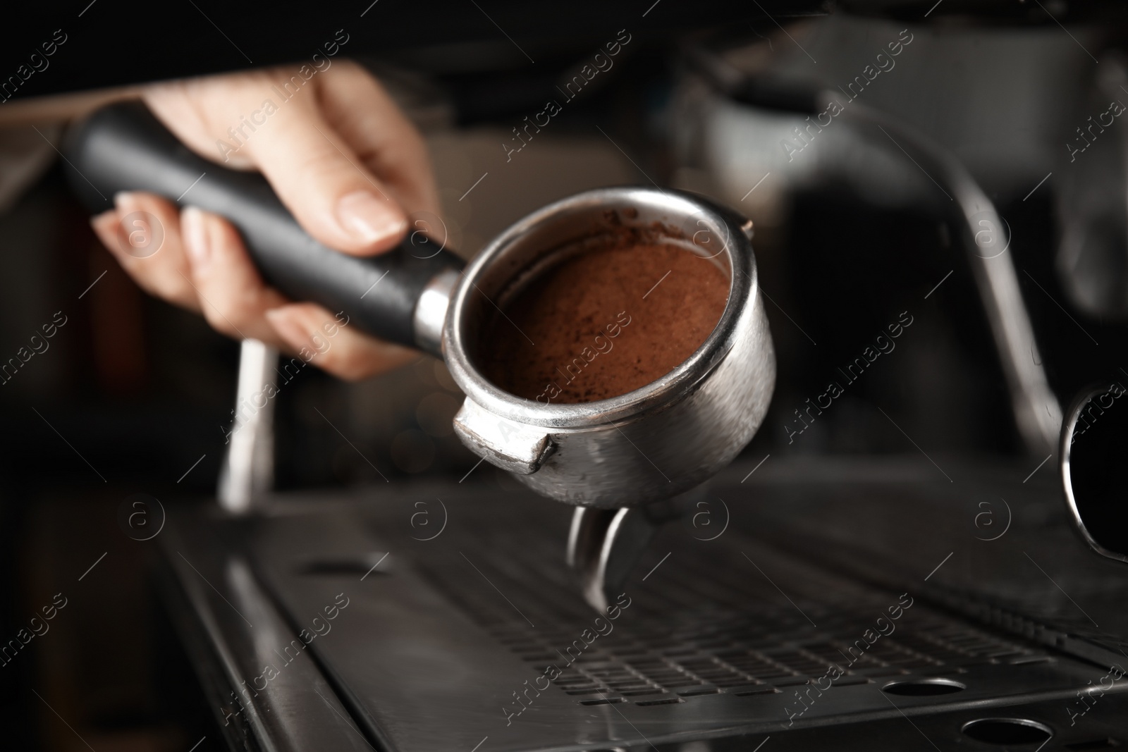 Photo of Barista making espresso using professional coffee machine, closeup