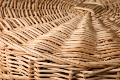 Photo of Lid of handmade wicker basket as background, closeup