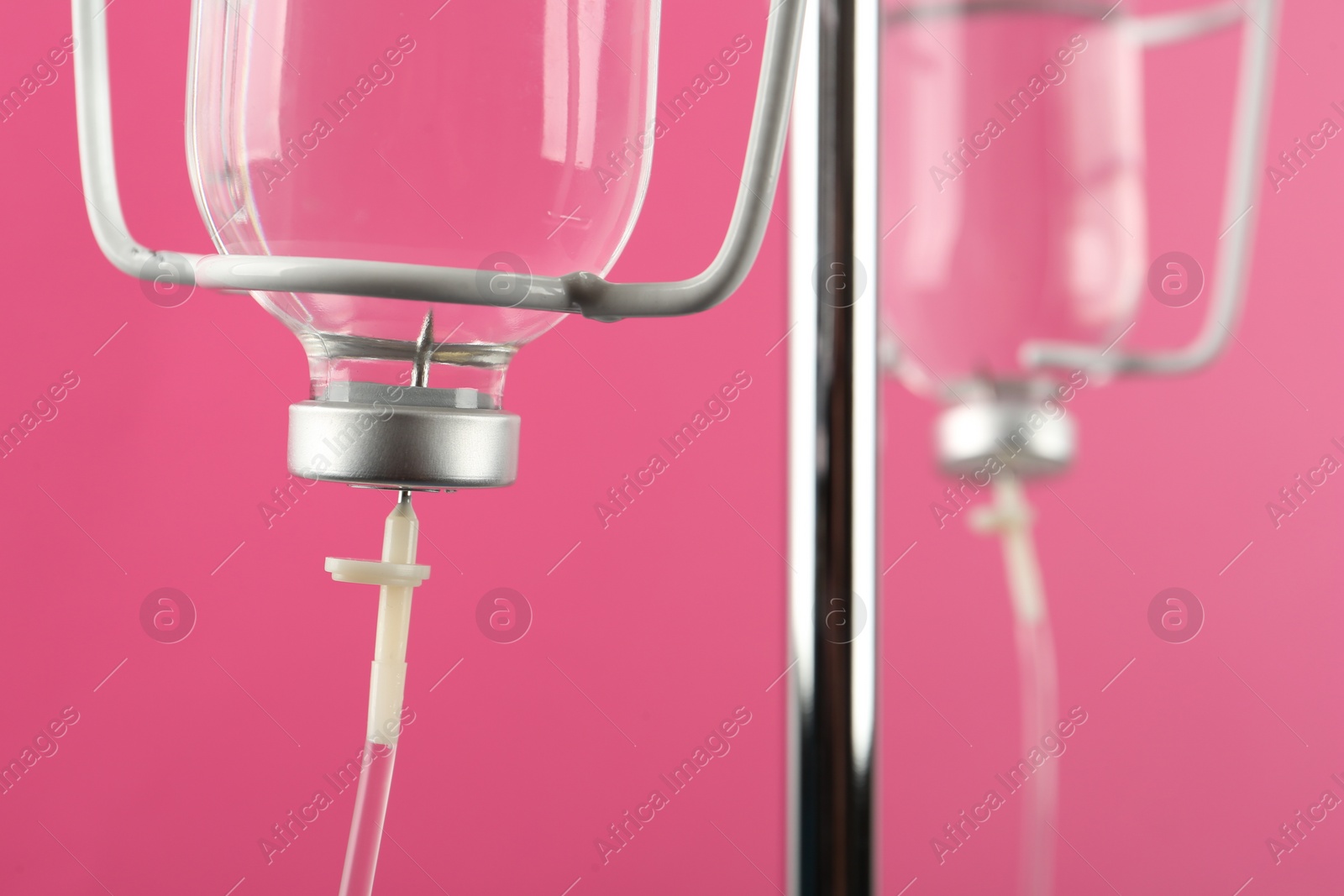 Photo of IV infusion set on pink background, closeup view