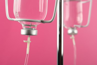 Photo of IV infusion set on pink background, closeup view