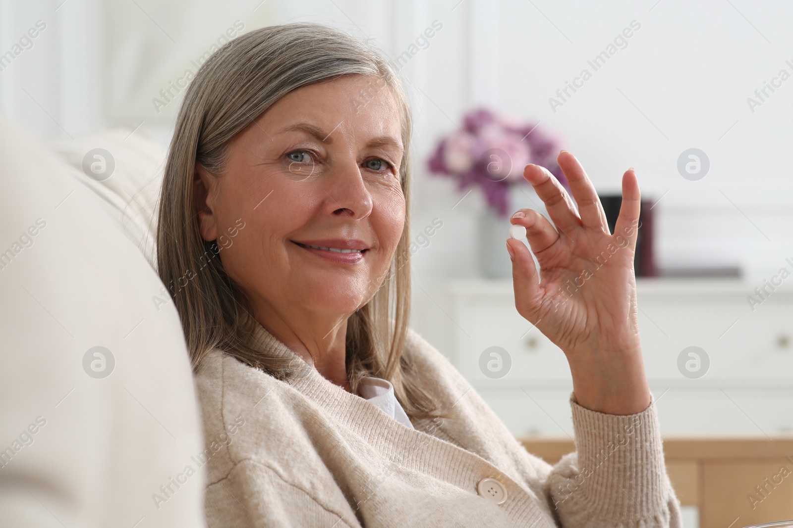 Photo of Beautiful senior woman with pill at home