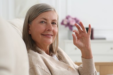 Photo of Beautiful senior woman with pill at home