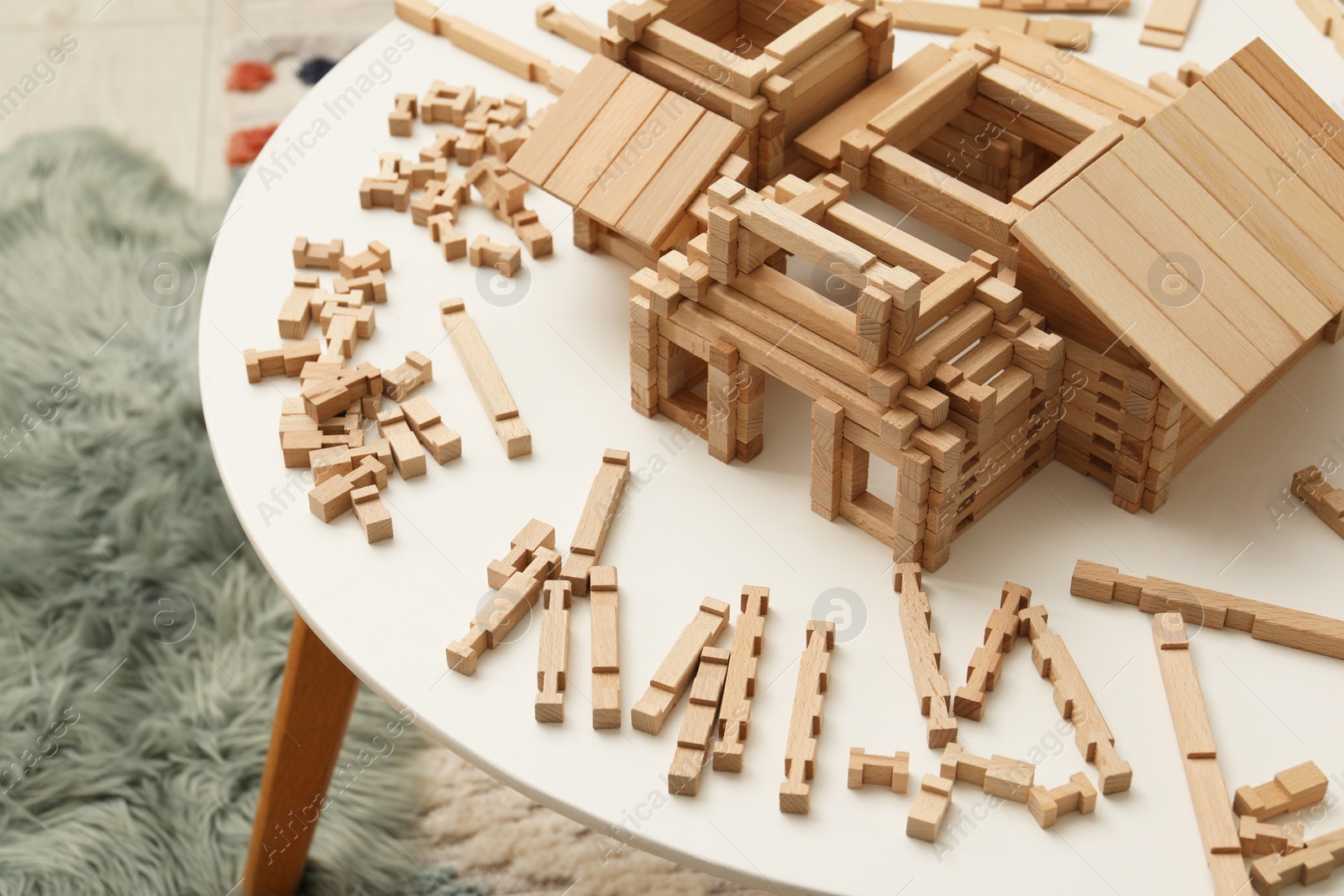 Photo of Wooden construction set on white table indoors. Children's toy