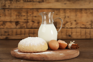 Photo of Raw eggs and other ingredients on wooden table. Baking pie