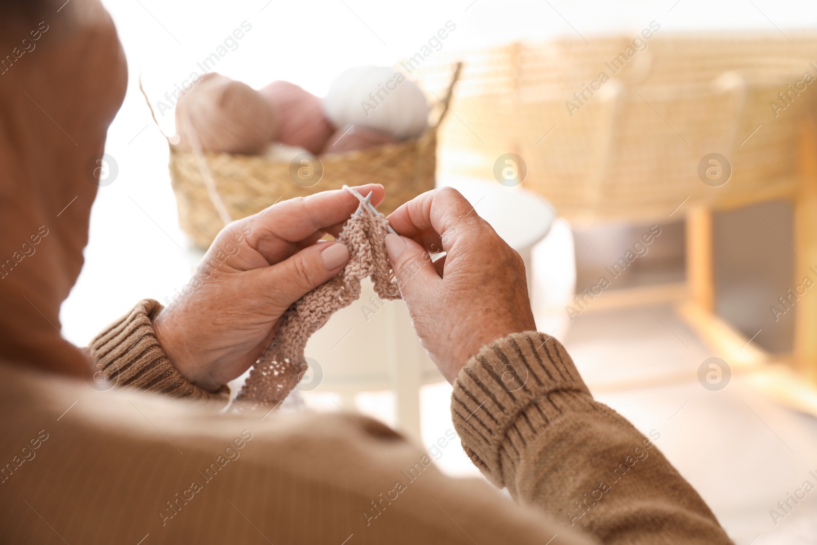 Photo of Elderly woman knitting at home, closeup. Creative hobby