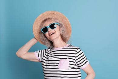 Photo of Portrait of mature woman in hipster outfit on color background