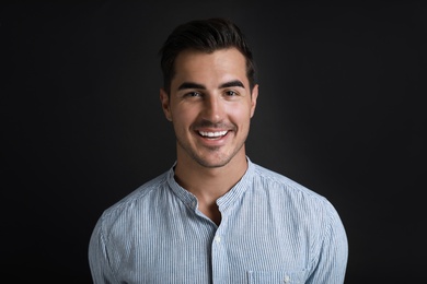 Portrait of handsome young man on black background