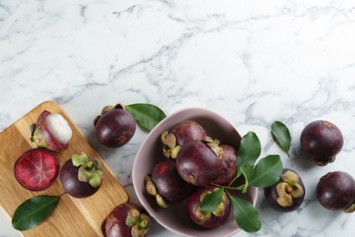 Fresh ripe mangosteen fruits on white marble table, flat lay. Space for text