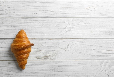 Photo of Tasty croissant and space for text on white wooden background, top view. French pastry