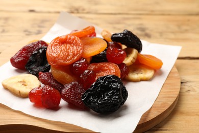 Photo of Mix of delicious dried fruits on wooden table, closeup